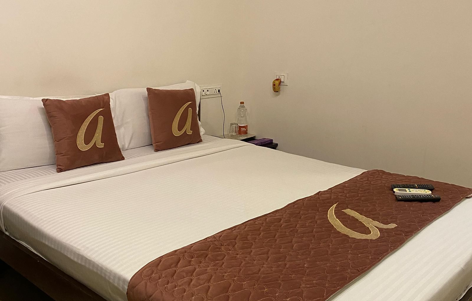 The Deluxe Double Room in Astra Hotels & Suites, HSR Sector 1, features a bed with an air conditioner mounted on the wall in the background.